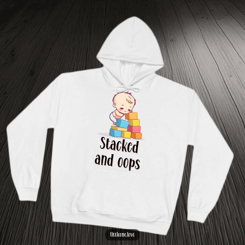 Funny hoodie showing a child character's attempt to stack colorful blocks ending in a humorous tumble. Relatable fun.